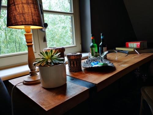 a table with a lamp and two bottles of wine at Casa Leone near Bruges with jacuzzi & parking in Ruddervoorde
