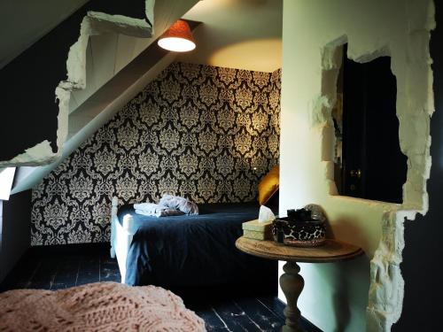 a bedroom with a bed and a table in a room at Casa Leone near Bruges with jacuzzi & parking in Ruddervoorde