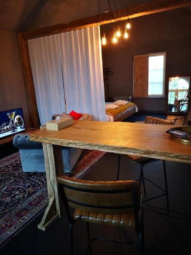 a room with a table with chairs and a bed at Casa Leone near Bruges with jacuzzi & parking in Ruddervoorde
