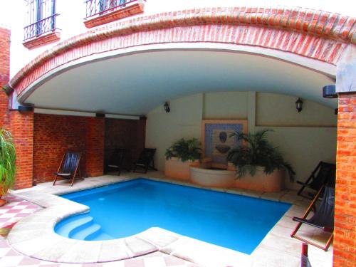 a swimming pool under an arch with chairs and plants at Posta Torreón in Concepción del Uruguay