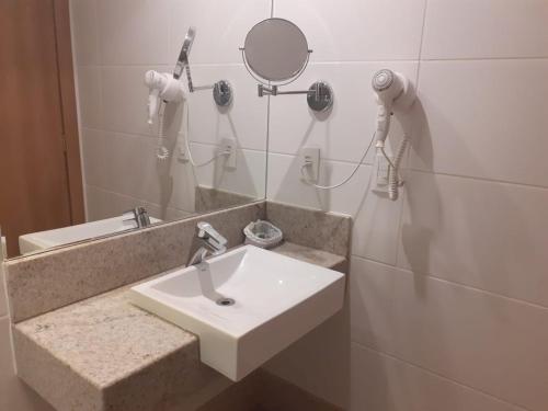 W łazience znajduje się umywalka i lustro. w obiekcie Vista Azul w mieście Pedra Azul