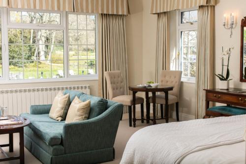 1 dormitorio con cama, sofá y mesa en Longueville Manor en Saint Helier