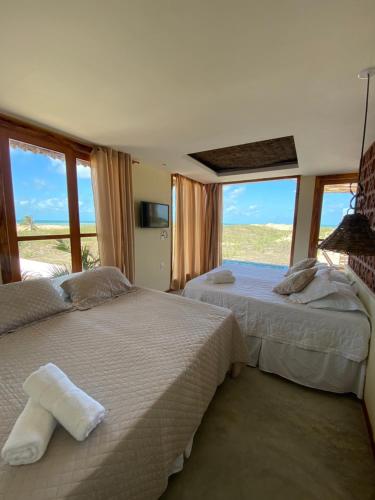 a bedroom with two beds and a view of the desert at Vila do Alto - Beach Homes in Itarema
