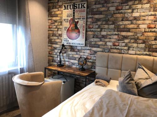 a bedroom with a guitar on a brick wall at Pension Ottenheide in Schloß Holte-Stukenbrock