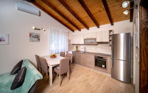 a kitchen with a table and a stainless steel refrigerator at Apartments Mama in Rab