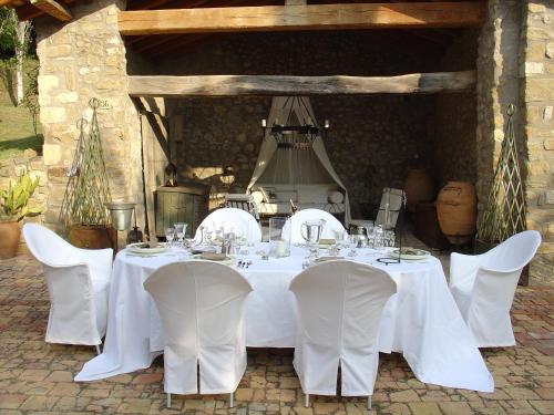 a table with white tables and chairs in at Can Serola in Sales del Llierca