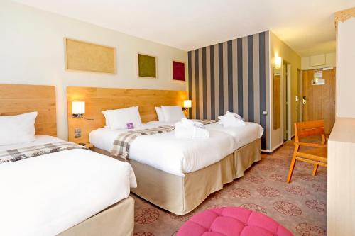 a hotel room with two beds and a chair at Mercure Saint-Lary in Saint-Lary-Soulan