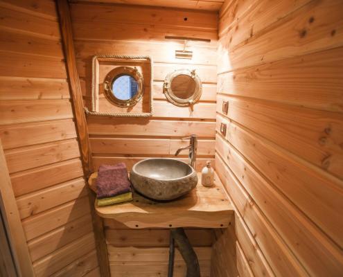 - une salle de bains pourvue d'un lavabo dans une cabine en bois dans l'établissement Parthénope - Les Cabanes du Chêne Rouvre, à Saint-Dié-des-Vosges