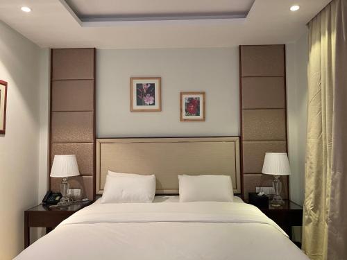 a bedroom with a large bed with two night stands and two lamps at Viluveli Holiday Retreat in Hanimaadhoo