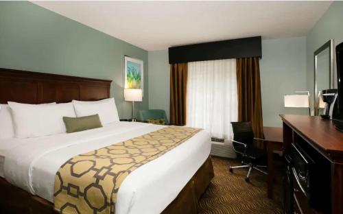 a hotel room with a large bed and a desk at Baymont Inn & Suites Braselton in Braselton