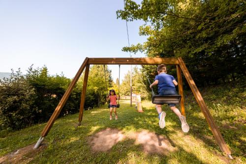 a boy and a girl playing on a swing at Agriturismo Parco Fiorito in Cortona