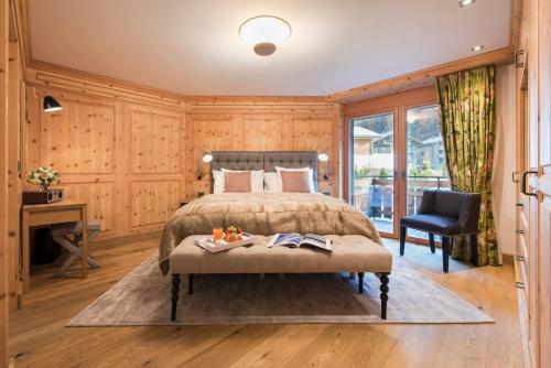 a bedroom with a bed and a desk and a chair at Chalet Shalimar in Zermatt