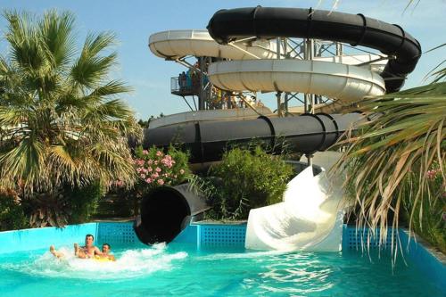 2 personnes dans un toboggan aquatique d'un complexe dans l'établissement studio avec climatisation WIFI parking piscine, au Cap d'Agde