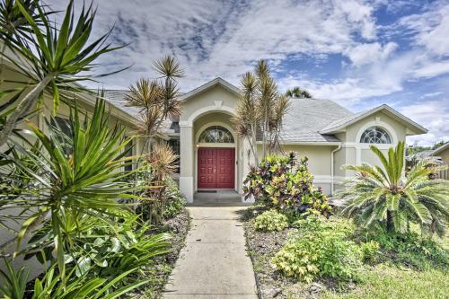 a house with a red door and palm trees at Cocoa Beach Paradise Screened Pool, Patio and Games in Merritt Island