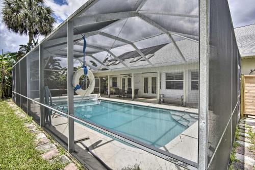 a glass house with a swimming pool with a pergola at Cocoa Beach Paradise Screened Pool, Patio and Games in Merritt Island