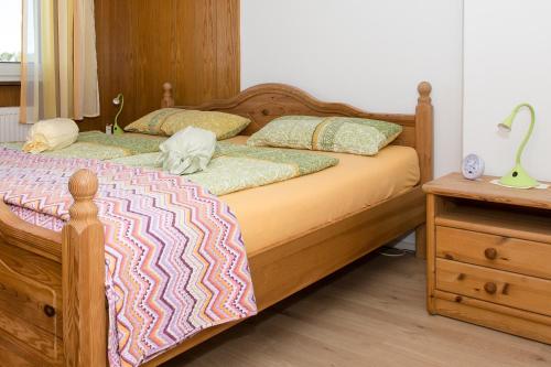 a bedroom with a wooden bed and a night stand at Casa Felicitas - Ferienwohnung & Studio in Möhnesee
