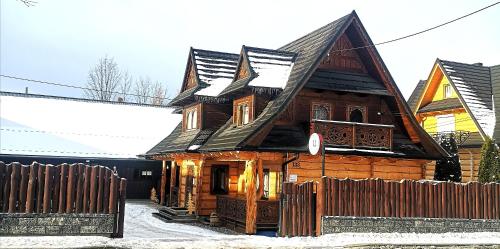 a wooden house with a wooden fence in front of it at U Dziadka in Chochołów