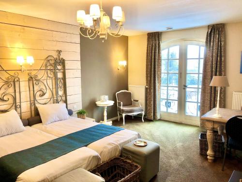 a hotel room with a large bed and a desk at Hotel & Restaurant - Auberge De Hilver in Diessen