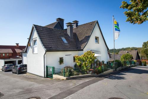 a white house with a black roof at Casa Felicitas - Ferienwohnung & Studio in Möhnesee