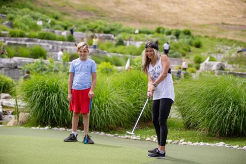 a woman and a child playing golf on a golf course at Blue Mountain Resort Village Suites in Blue Mountains