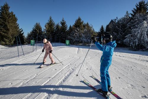 two people standing on skis in the snow at Blue Mountain Resort Village Suites in Blue Mountains