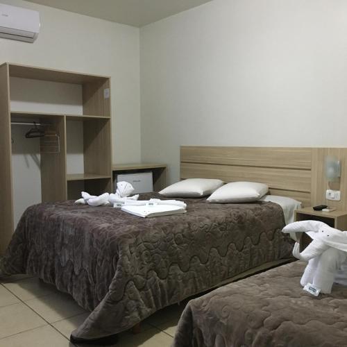a hotel room with two beds with towels on them at Hotel Fontana in Tapejara