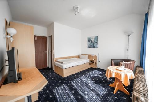 Kleines Zimmer mit einem Bett und einem Tisch in der Unterkunft Hotel Joh in Bad Salzuflen