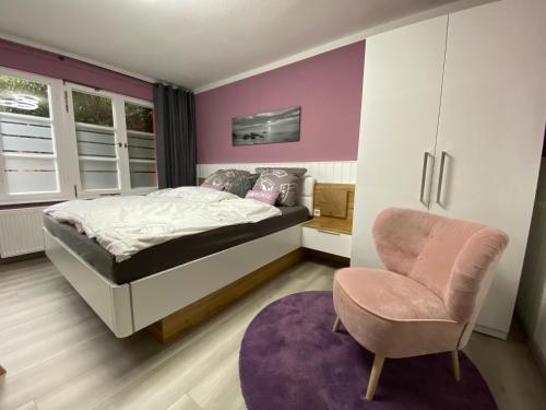 un dormitorio con una cama y una silla en Ferienzimmer Am Strom 34, en Rostock
