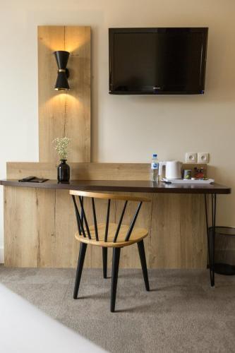 a wooden table with a chair in a room at Best Western Le Bois de la Marche in Poitiers