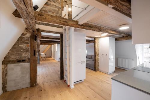 una cocina en el ático con vigas de madera y paredes blancas en Johannis Suite - Schrangen-Suites-1389 en Lüneburg