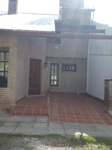 a brick house with a front porch and a door at Casita de las Sierras in Río Ceballos