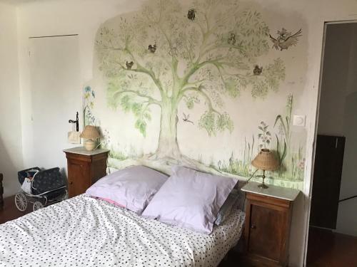 a bedroom with a tree mural on the wall at Mas de Fontclovisse in Draguignan