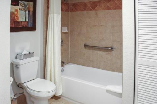 a bathroom with a white toilet and a bath tub at Hilton Vacation Club Polynesian Isles Kissimmee in Kissimmee