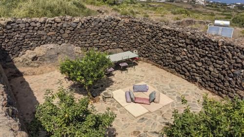 an overhead view of a table and chairs in front of a stone wall at Horizon Pantelleria in Pantelleria
