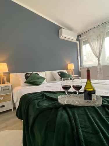 a bedroom with a bed with two glasses of wine at Apartman Jež - free parking, self check in in Karlovac