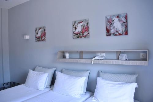 a bed with white pillows and two pictures above it at Liprando in Naousa