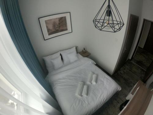 a bedroom with a bed with white sheets and pillows at Stary Koszalin Hostel & Hotel Services in Koszalin