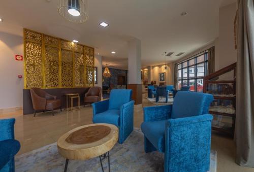 a waiting room with blue chairs and a table at Hotel Playa de Laxe in Laxe
