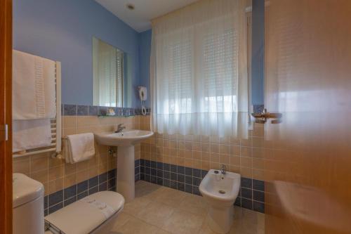 a bathroom with a sink and a toilet and a sink at Hotel Playa de Laxe in Laxe