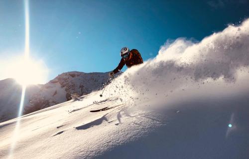a person is skiing down a snow covered slope at Lodge am Krippenstein in Obertraun