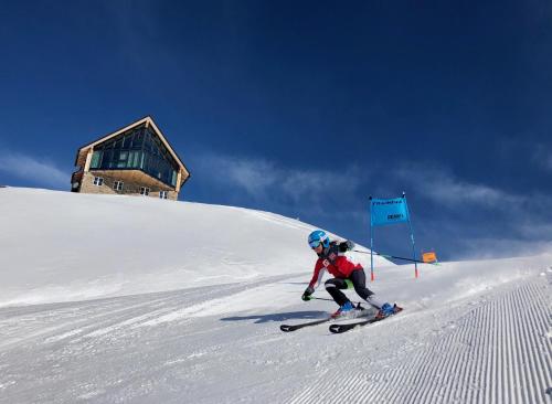 a person is skiing down a snow covered slope at Lodge am Krippenstein in Obertraun