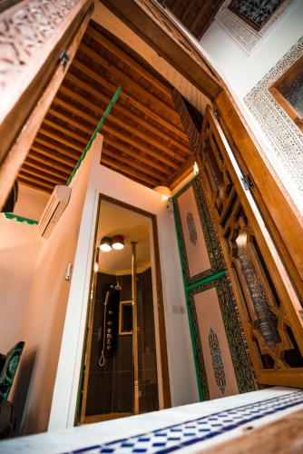 a room with a wooden ceiling and a door at Riad Fes Nass Zmane in Fès