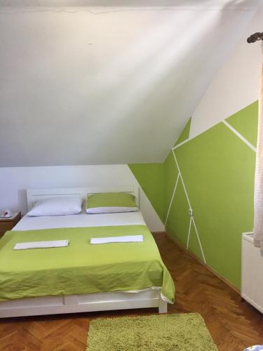 a bedroom with a bed with green and white walls at Hostel Lega House in Osijek