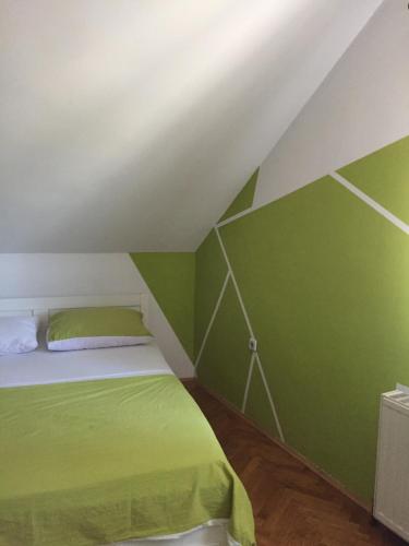 a green bedroom with a bed in a attic at Hostel Lega House in Osijek