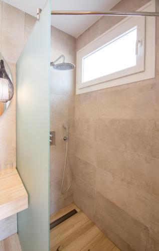 a bathroom with a shower with a window at Fortuna in Los Caños de Meca