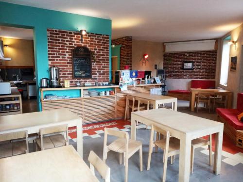 un restaurant avec des tables, des chaises et un comptoir dans l'établissement La Maison Rouge - Backpacker Hostel, à Saint-Étienne