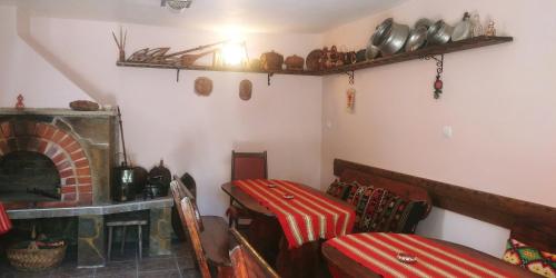 a room with a fireplace and a bed and a table at Guest House Vodolei in Kotel