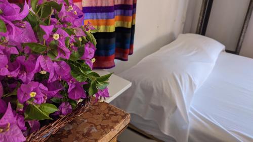 a bedroom with a bed and purple flowers on a table at Horizon Pantelleria in Pantelleria