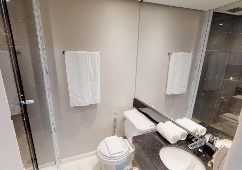 a bathroom with a toilet and a sink and a shower at Estanplaza Funchal Faria Lima in Sao Paulo