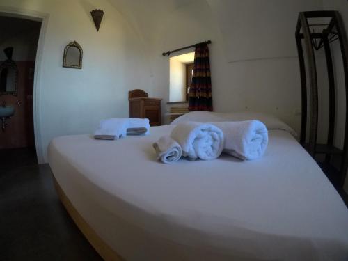 a bedroom with a bed with towels on it at Horizon Pantelleria in Pantelleria